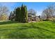 Large green backyard with mature trees and lush grass, featuring a deck with a covered outdoor seating area at 13892 Adios Pass, Carmel, IN 46032