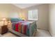Cozy bedroom with a colorful quilt, soft carpet, and a bright window for natural light at 13892 Adios Pass, Carmel, IN 46032
