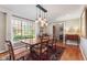 Formal dining area boasts hardwood floors, traditional furniture, and natural light from large window at 13892 Adios Pass, Carmel, IN 46032