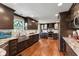 Beautiful kitchen with stainless steel appliances, dark wood cabinets, granite countertops, and a farmhouse sink at 13892 Adios Pass, Carmel, IN 46032