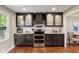 Modern kitchen with dark wood cabinets, granite countertops, stainless steel appliances, and hardwood floors at 13892 Adios Pass, Carmel, IN 46032