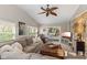 Inviting living room featuring a comfortable sectional sofa, leather ottoman, and a decorative ceiling fan at 13892 Adios Pass, Carmel, IN 46032
