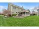 Large grassy backyard with a screened-in porch, fire pit, and lush green lawn at 14910 Declaration Dr, Westfield, IN 46074