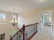 Bright hallway with chandelier and wood railing, offering a glimpse into the home's elegant design at 14910 Declaration Dr, Westfield, IN 46074