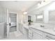 Luxurious bathroom with double sinks, white cabinets, and a view into the bedroom at 15341 Montfort Dr, Noblesville, IN 46062