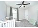 Neutral Bedroom with a white crib, a ceiling fan, gray carpeting, and large window that offers ample sunlight at 15341 Montfort Dr, Noblesville, IN 46062