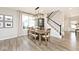 Inviting dining room with stylish light fixture, wood table, and stairway view at 15341 Montfort Dr, Noblesville, IN 46062