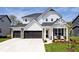 Charming two-story home with a three-car garage and a welcoming front porch seating area at 15341 Montfort Dr, Noblesville, IN 46062