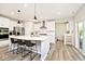 Bright open-concept kitchen with stainless steel appliances, white cabinets, an island with seating, and access to the patio at 15341 Montfort Dr, Noblesville, IN 46062