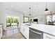 Open-concept kitchen featuring white cabinets, a central island, and stainless steel appliances, seamlessly connecting to the living space at 15341 Montfort Dr, Noblesville, IN 46062