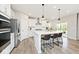 Bright kitchen featuring stainless steel appliances, white cabinets, an island with pendant lighting, and hardwood floors at 15341 Montfort Dr, Noblesville, IN 46062