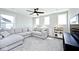 Cozy living room with a large grey sectional sofa, plush carpet, and a modern ceiling fan at 15341 Montfort Dr, Noblesville, IN 46062