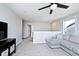 Spacious living room with a grey sectional sofa, neutral carpet, and a black ceiling fan at 15341 Montfort Dr, Noblesville, IN 46062