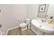 Stylish powder room featuring a pedestal sink, wood-look flooring, and modern fixtures at 15341 Montfort Dr, Noblesville, IN 46062