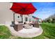 Backyard patio with outdoor seating, fire pit, and red umbrella at 15762 Hargray Dr, Noblesville, IN 46062