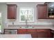 Close-up of the kitchen with stainless steel appliances, a view from the window, and cherry wood cabinets at 15762 Hargray Dr, Noblesville, IN 46062