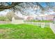 Spacious backyard featuring a large tree, a shed, a white picket fence and a playset at 1614 Ashley Dr, Lebanon, IN 46052