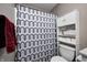 Bathroom featuring a patterned shower curtain with a repeating stripe pattern, a toilet, and storage shelves at 1614 Ashley Dr, Lebanon, IN 46052