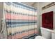 Cozy bathroom featuring a vibrant shower curtain with a repeating stripe pattern and neutral colored walls at 1614 Ashley Dr, Lebanon, IN 46052