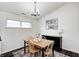 Bright dining area features a wooden table, black accent cabinet, decorative chandelier, and colorful area rug at 1614 Ashley Dr, Lebanon, IN 46052