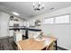 Open layout kitchen and dining room features white cabinets, stainless appliances, and a wooden table at 1614 Ashley Dr, Lebanon, IN 46052