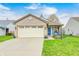 Charming single-story brick home featuring a well-manicured lawn, attached garage, and inviting curb appeal at 1614 Ashley Dr, Lebanon, IN 46052