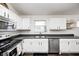 Bright kitchen features white cabinets, gray countertops, stainless steel appliances, and dark hardwood floors at 1614 Ashley Dr, Lebanon, IN 46052