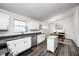 Open kitchen features white cabinets and stainless appliances, with a dining area and hardwood floors at 1614 Ashley Dr, Lebanon, IN 46052