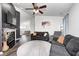 Comfortable living room with dark sofas, fireplace, ceiling fan, and plentiful light at 1614 Ashley Dr, Lebanon, IN 46052