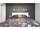 Bright main bedroom features a black accent wall, neutral walls, carpet floors, and a shelf above the headboard at 1614 Ashley Dr, Lebanon, IN 46052