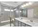 Bathroom showcasing a tiled shower, double vanity with quartz countertop, and large mirror at 17269 Dallington St, Westfield, IN 46074