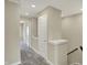 Upstairs hallway with neutral-toned walls and carpet, featuring multiple doors and a staircase at 17269 Dallington St, Westfield, IN 46074