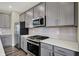 Kitchen showcasing stainless steel appliances and gray cabinetry, offering ample storage at 17269 Dallington St, Westfield, IN 46074