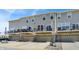View of the townhome exteriors with covered parking and a small outdoor balcony with seating at 17269 Dallington St, Westfield, IN 46074