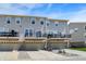 Exterior view of townhomes with multiple windows, garages, and outdoor seating areas at 17269 Dallington St, Westfield, IN 46074