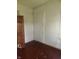 Bedroom with unfinished drywall and hardwood floors, featuring an interior door at 1901 S F St, Elwood, IN 46036