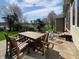 A backyard patio has a wooden table and chairs with a grassy yard and lake in the background at 1995 Brookfield Ct, Columbus, IN 47201