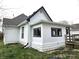 Side view of the home displaying the white siding, black trim, windows, and the well-maintained lawn at 212 W Burnside Ave, Fairland, IN 46126