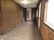 Wood-paneled hallway features modern vinyl flooring, and a doorway leading to another room at 212 W Burnside Ave, Fairland, IN 46126