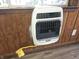 Wall-mounted heater in room featuring wood paneling and vinyl floors, offering efficient heating at 212 W Burnside Ave, Fairland, IN 46126