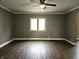 Spacious living room featuring hardwood floors, a ceiling fan, and a large window that offers plenty of natural light at 212 W Burnside Ave, Fairland, IN 46126