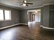 Bright living room showcasing hardwood floors, a ceiling fan, and an open layout that leads to other rooms in the home at 212 W Burnside Ave, Fairland, IN 46126
