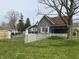 Rear view of the house with white fence in the yard and quaint architectural details at 214 S 10Th St, Elwood, IN 46036