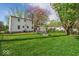 Exterior view of the back of the house with a lush green lawn and fire pit area at 2204 Pamela Dr, Indianapolis, IN 46220
