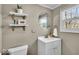 Bathroom featuring a white vanity, round mirror, decorative shelves, and window at 2204 Pamela Dr, Indianapolis, IN 46220