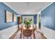 Charming dining area with a wooden table and chairs, blue walls and access to the backyard at 2204 Pamela Dr, Indianapolis, IN 46220