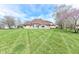 Expansive backyard featuring lush, manicured lawn, backing to mature trees, with a lovely outdoor deck at 2446 Quiet Way, Indianapolis, IN 46239