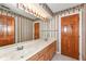 Bathroom featuring a double vanity, framed mirror, and wallpaper at 2446 Quiet Way, Indianapolis, IN 46239