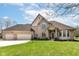 A well-kept brick home has a large, three-car garage and lovely landscaping at 2446 Quiet Way, Indianapolis, IN 46239