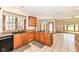 Well-lit kitchen features wood cabinets, granite countertops, black appliances, and a window overlooking the backyard at 2446 Quiet Way, Indianapolis, IN 46239